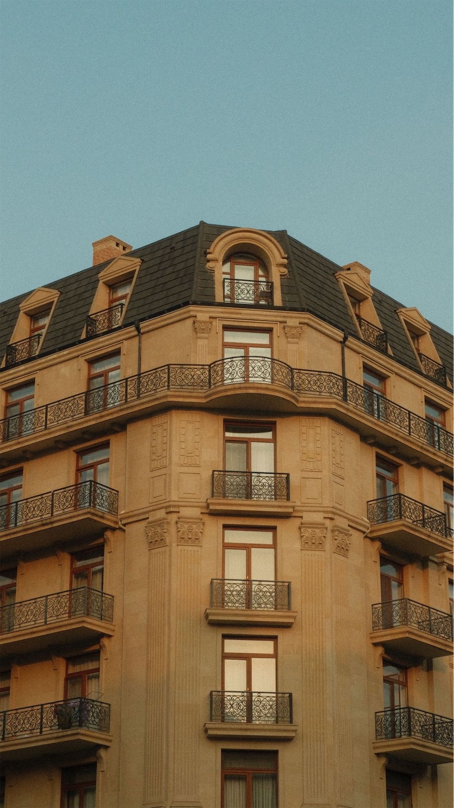 Klassisches Eckhaus mit schmiedeeisernen Balkonen im Abendlicht